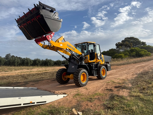 HandyMax HM22 wheel loader with its bucket raised on a farm track
