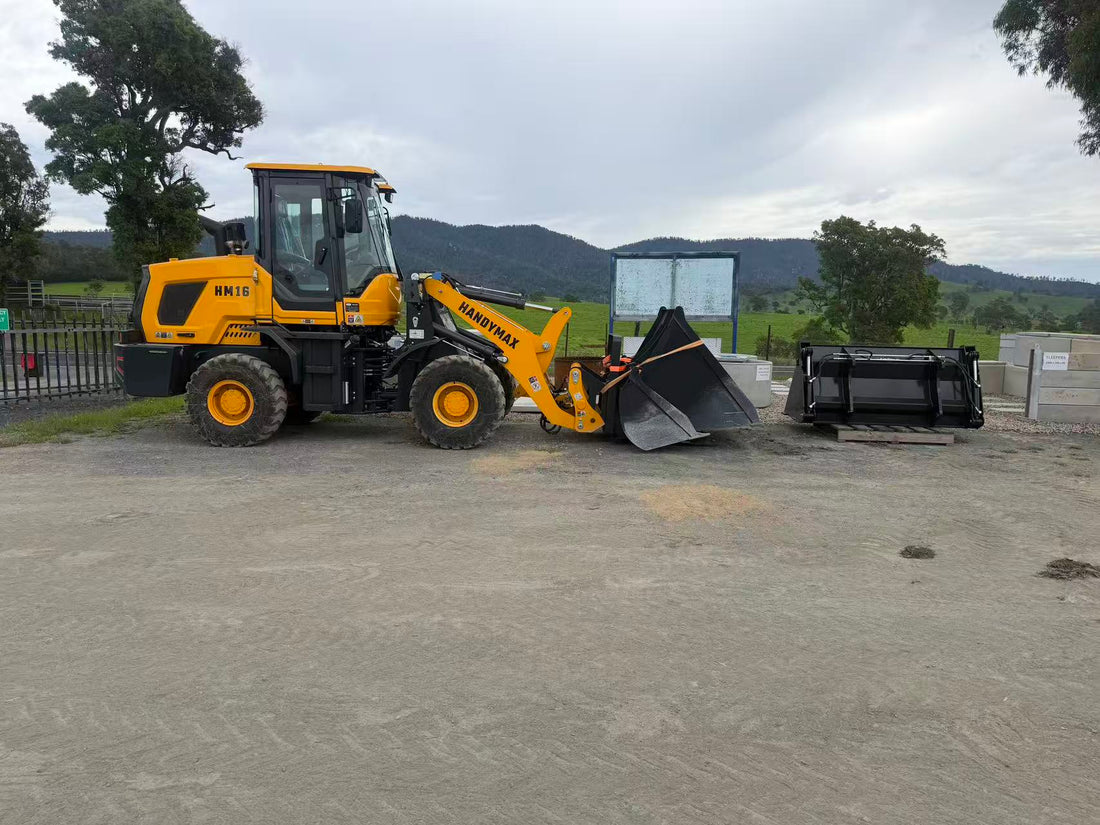 HandyMax HM16 wheel loader on gravel lot with rolling hills in background