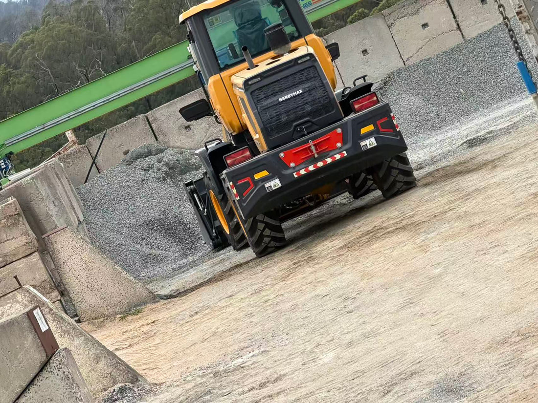HandyMax HM22 wheel loader parked next to gravel stockpile on concrete pad