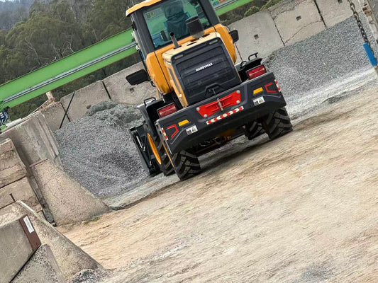 HandyMax HM22 wheel loader parked next to gravel stockpile on concrete pad